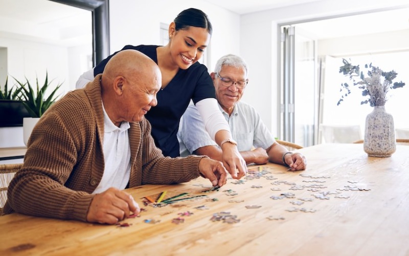 Residents and caregiver solving a puzzle